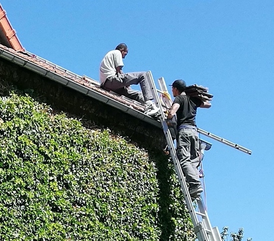 2 couvreurs sur un toit en rénovation