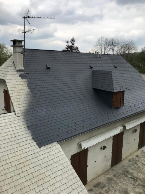 Traitement hydrofuge coloré appliqué sur une toiture à Villetaneuse : la partie déjà traitée apparaît en gris foncé